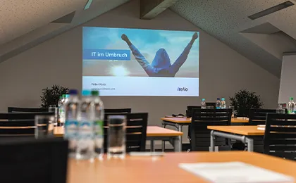 Besprechungsraum in der itelio-Firmenzentrale mit Blick auf eine Präsentation.