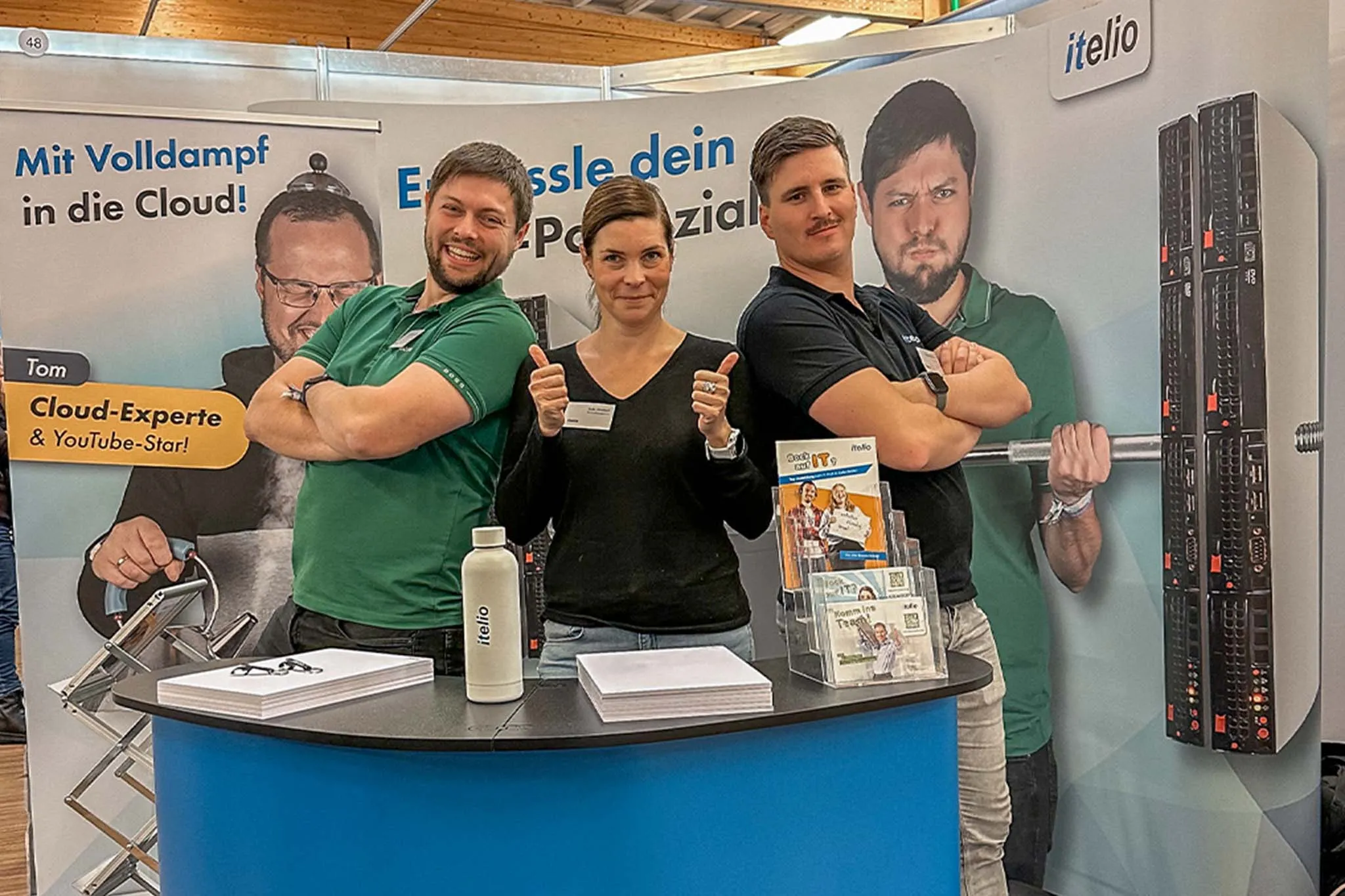 Personalmanagerin Julia Mayr mit zwei langjährigen Mitarbeitern auf einer Berufsmesse im Jahr 2023.