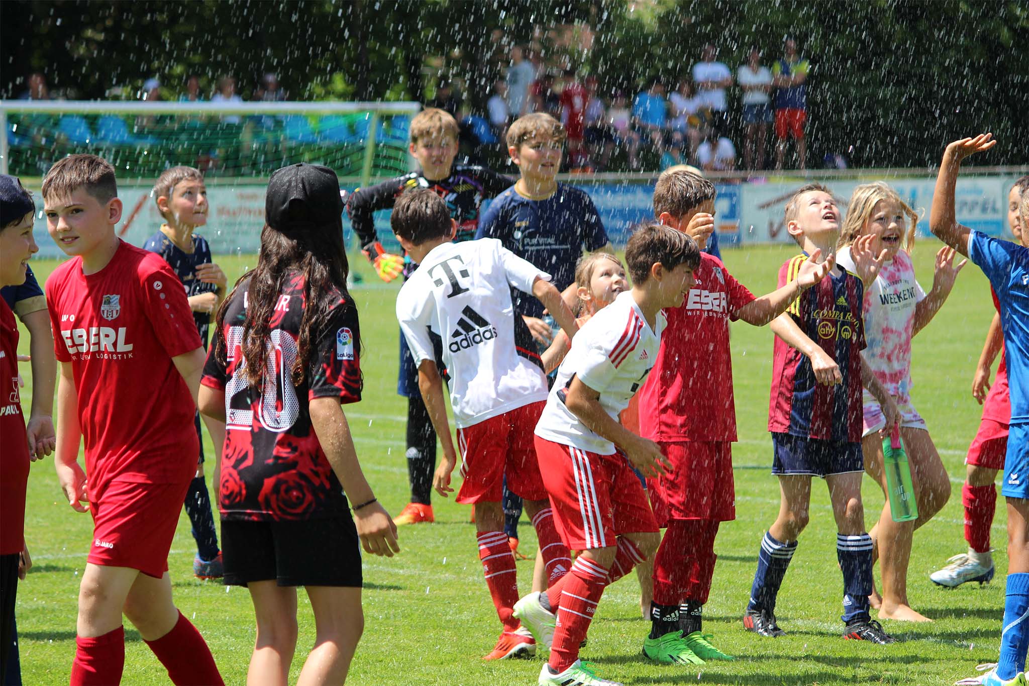 Spieler und Zuschauer genießen den Sprühregen beim itelio Cup 2023